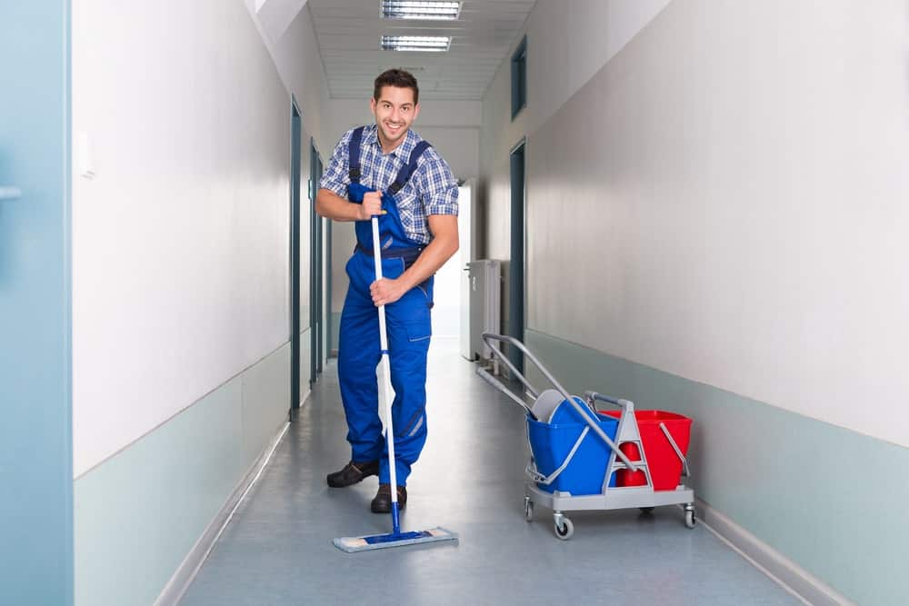 Janitor cleaning hallway and performing commercial cleaning services