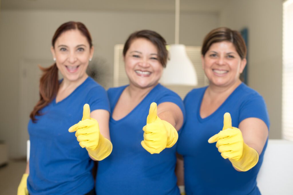 Three Janitorial female worker giving a thumbs up