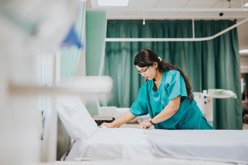 Hospital janitor performing EVS in patient room